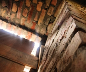 Close-up black-and-white image of textured stone walls with red lighting.