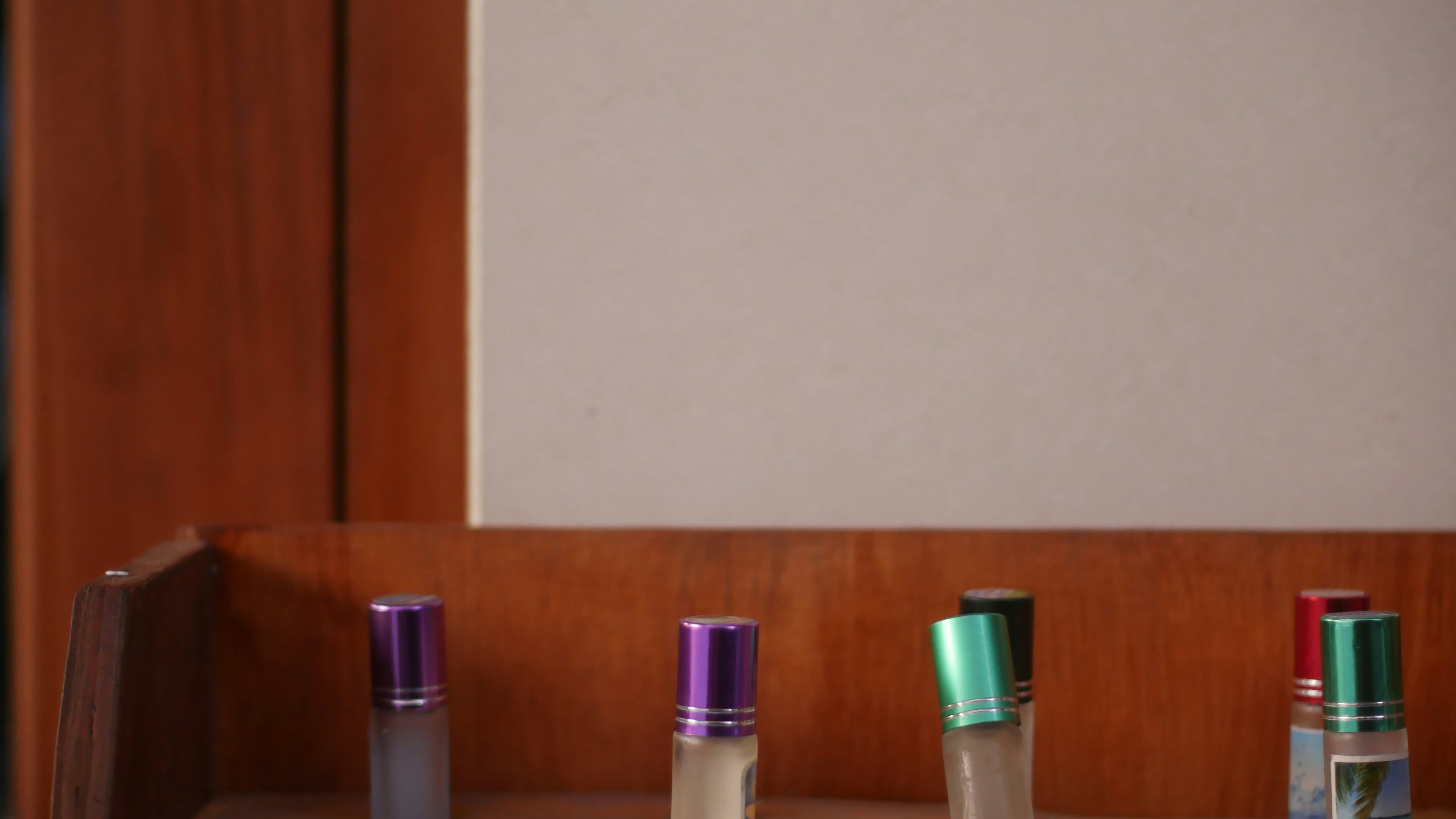 مجموعة زجاجات عطور متنوعة على رف خشبي