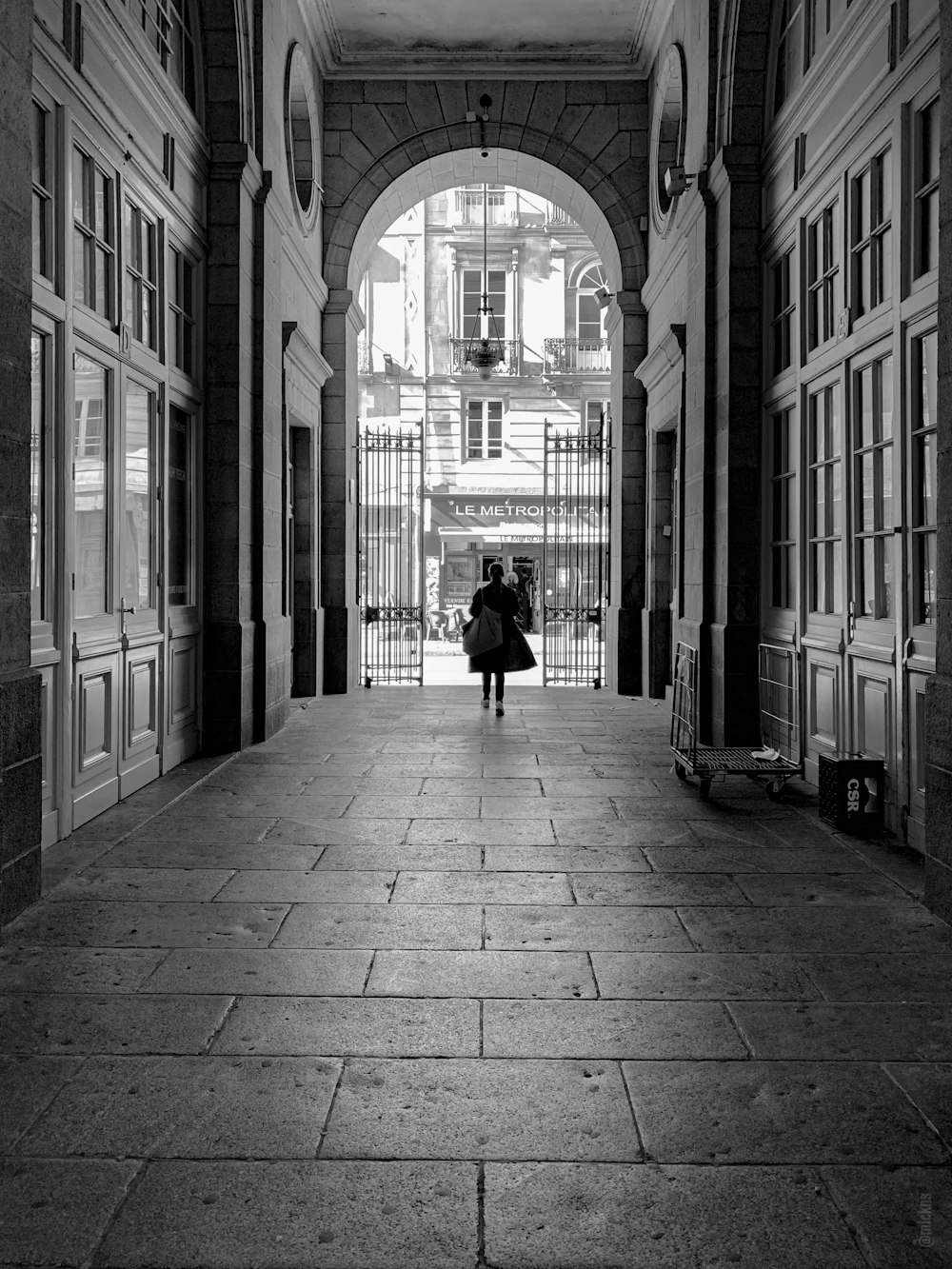 grayscale photography of person walking on hallway