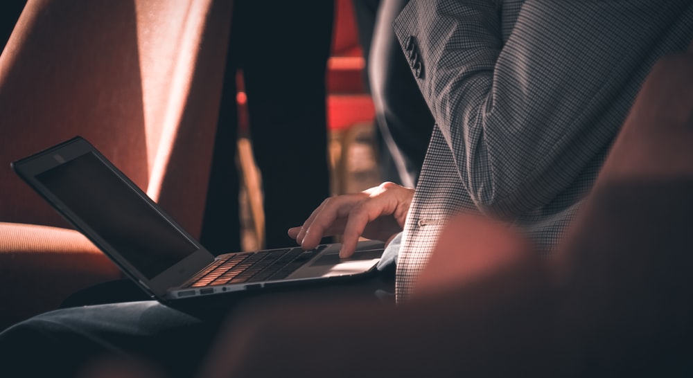 woman carrying silver MacBook