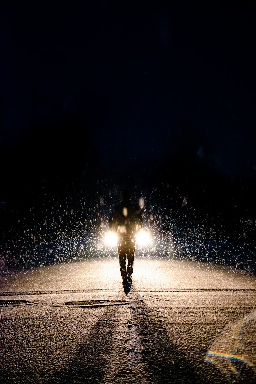 photography of man walking on road during nighttime
