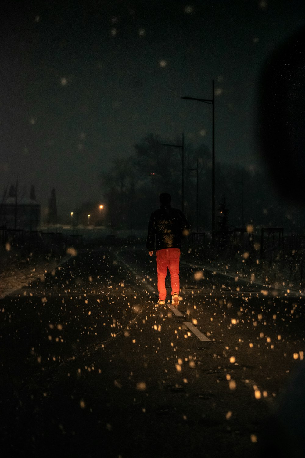 man standing on road during nighttime