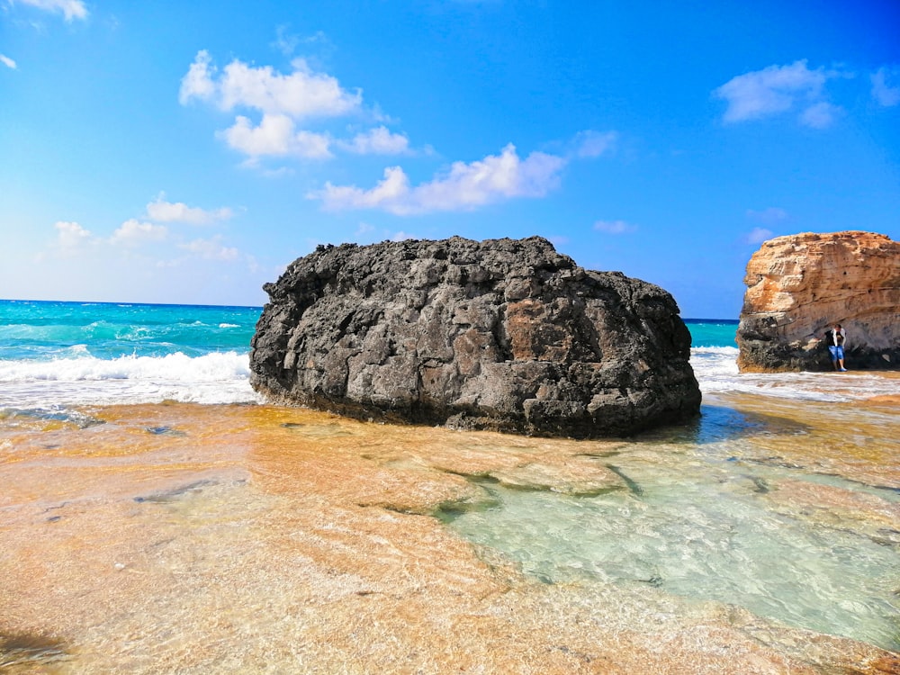 brown rock on beach line