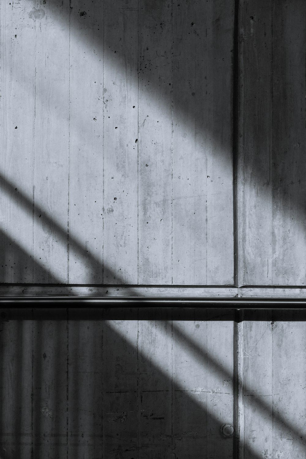 a black and white photo of a bench and a wall