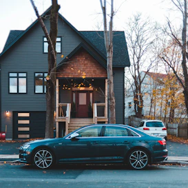 black sedan parked outside house