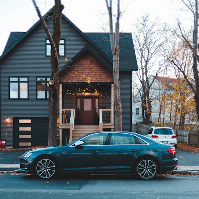 black sedan parked outside house
