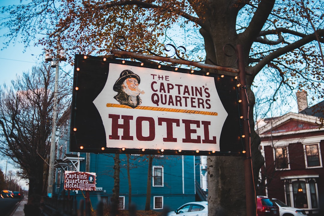 The Captain's Quarters Hotel signage near tall tree