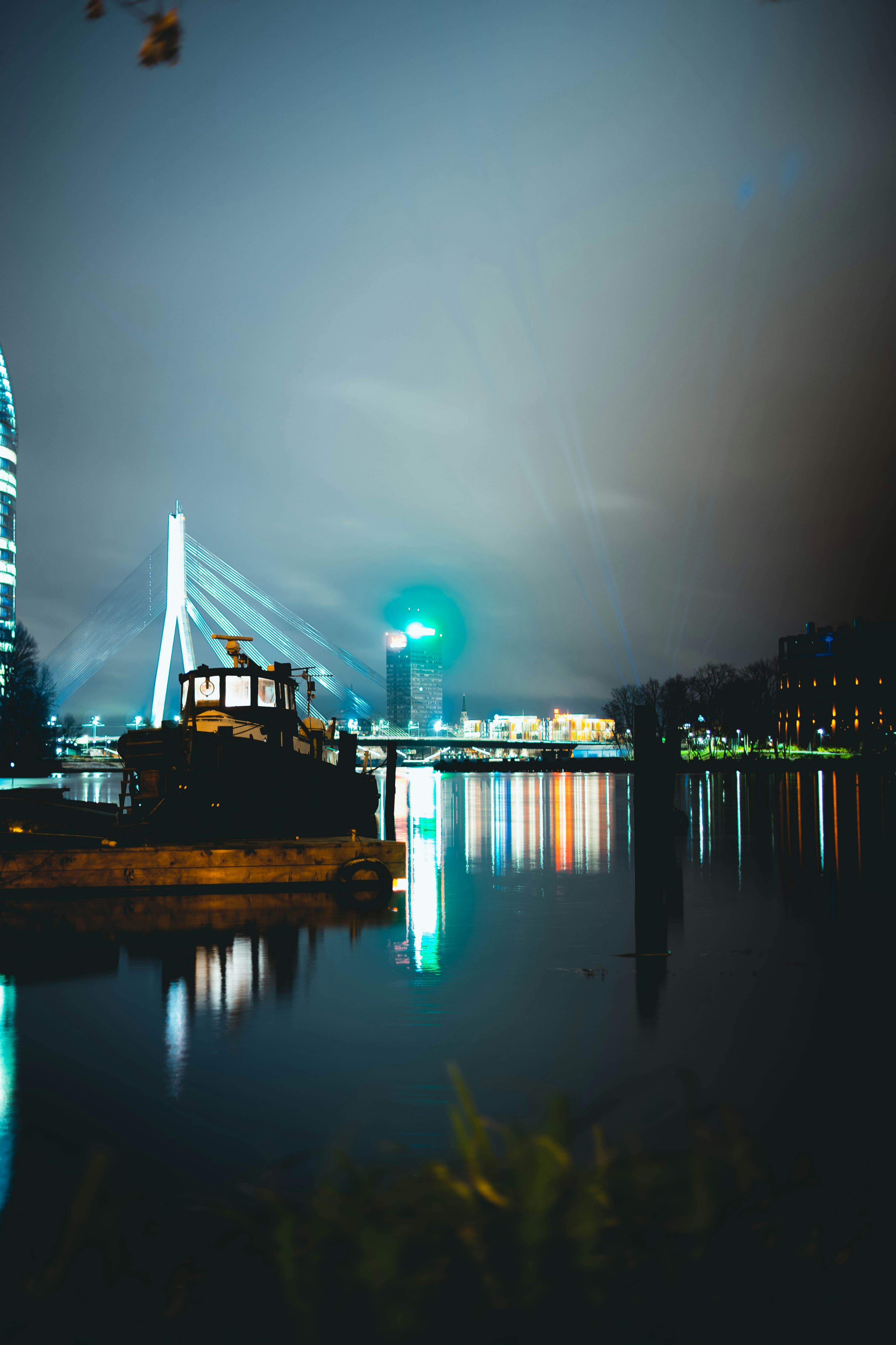 boat on dock silhouette and bridge with lights at night