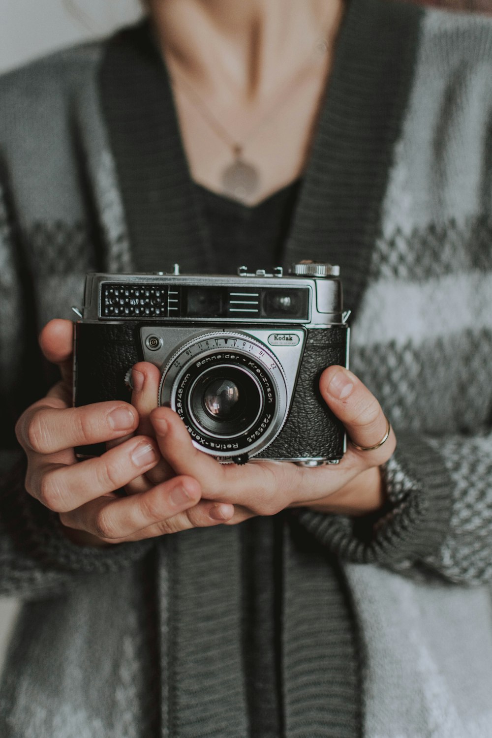 woman holding grey and black film camera