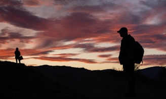A vibrant sunset over Idaho's rolling hills, with the couple silhouetted against the colorful sky.