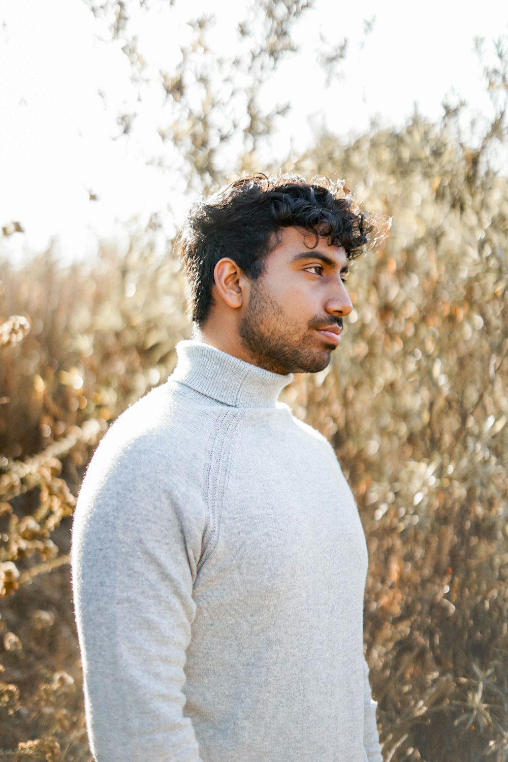 man standing beside dried plants