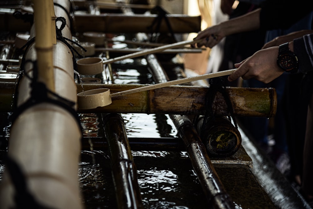 person holding brown ladles onto flowing water