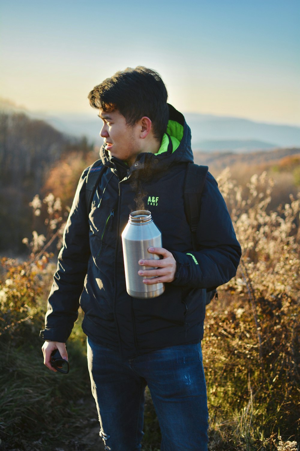 man holding grey stainless steel bottle