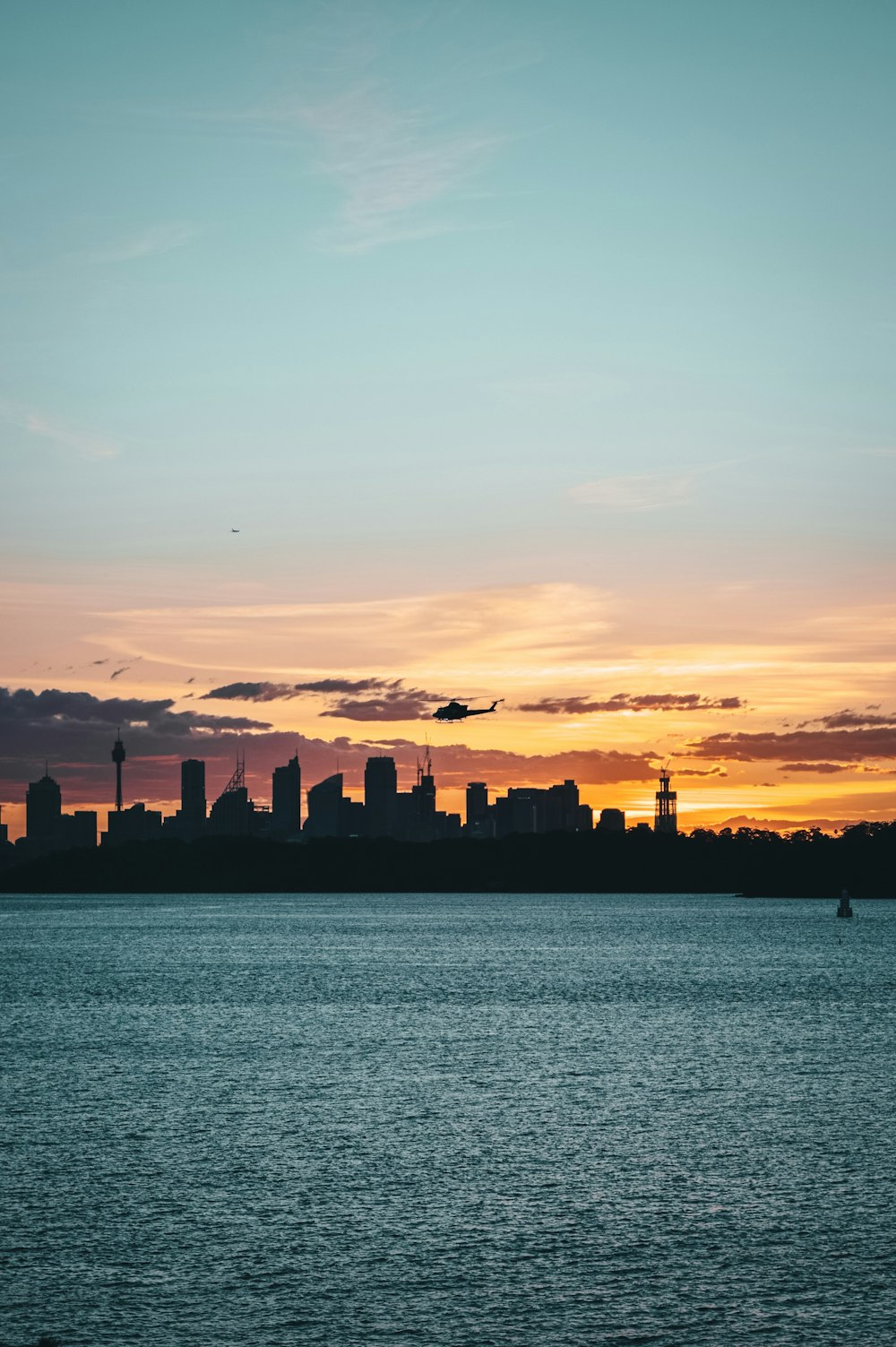 silhouette photography of cityscape under a calm blue sky during golden hour