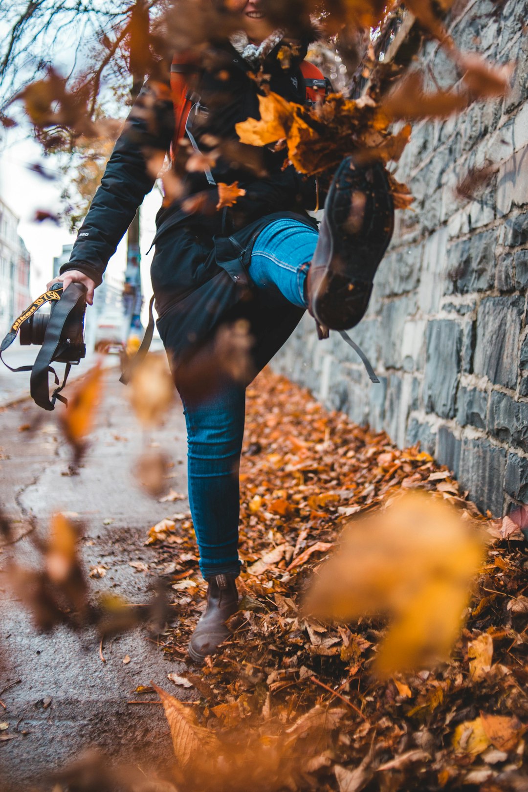 time lapse photography of woman kicking leaves from the ground