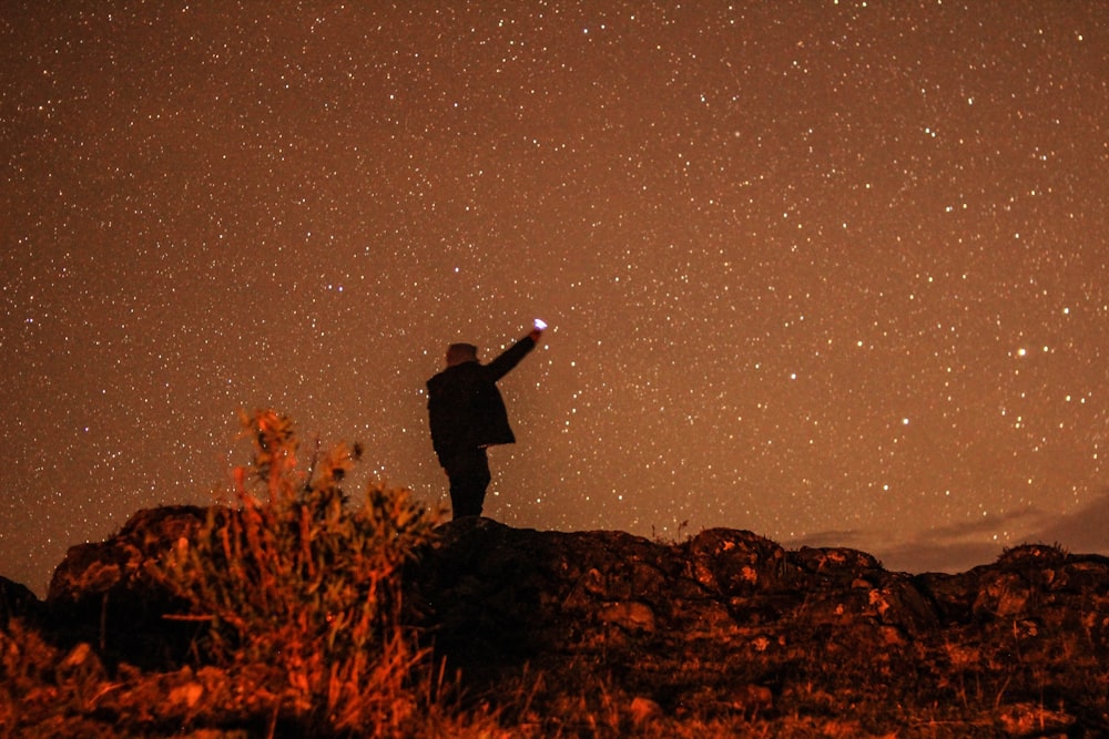 man standing on hill during nighttime