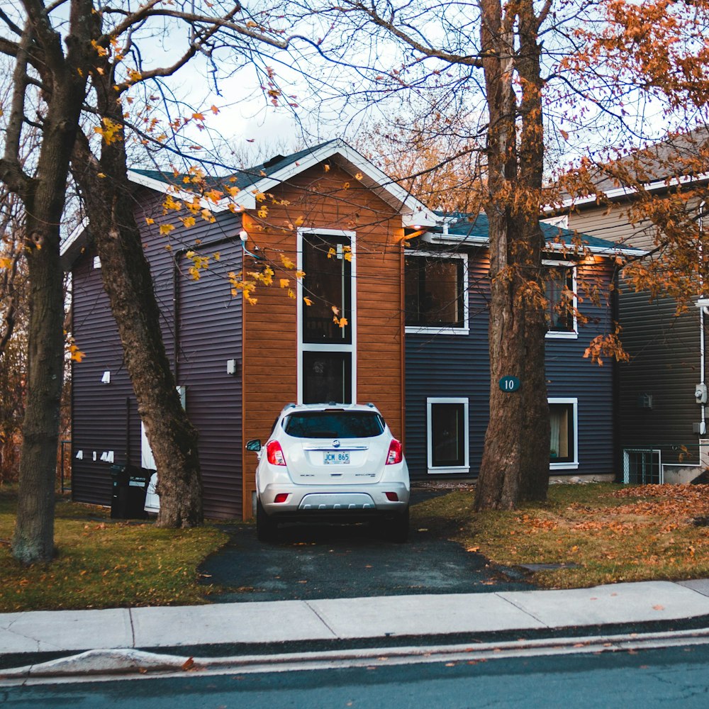 white SUV parked in front of house during daytime