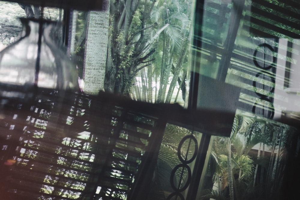 a close up of a window with trees in the background