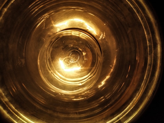 Close-up of a glowing copper vortex coil emitting soft harmonic light in a serene healing space.