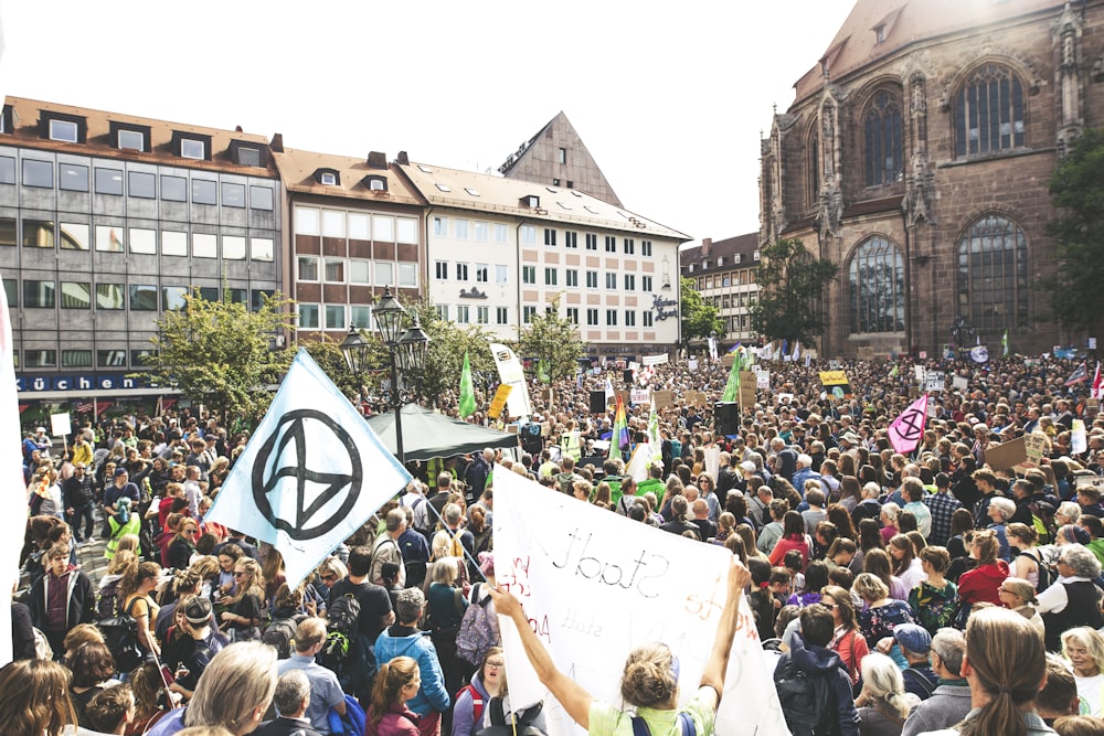 crowd of people by concrete building during daytime