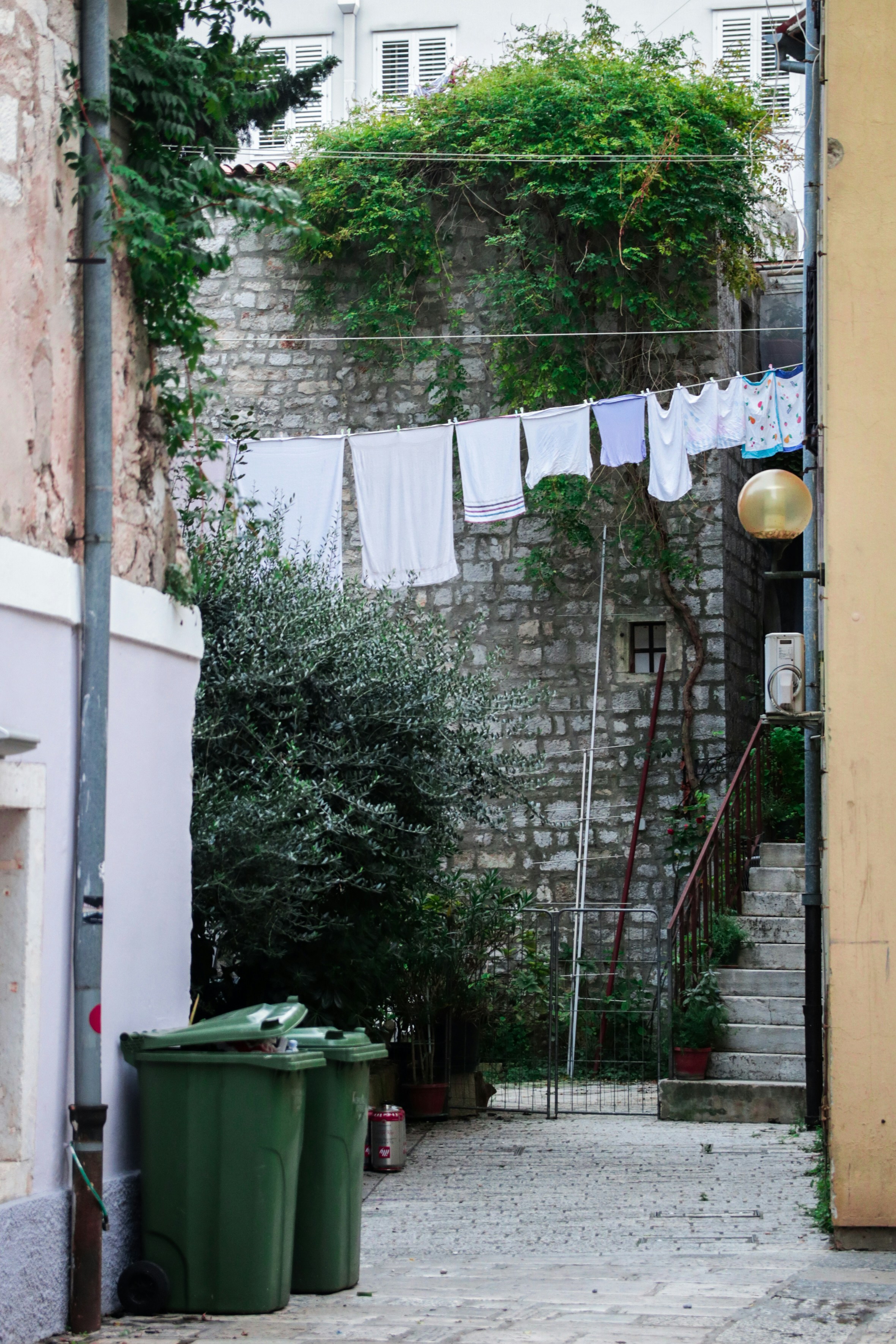 hung clothes near buildings and trash containers