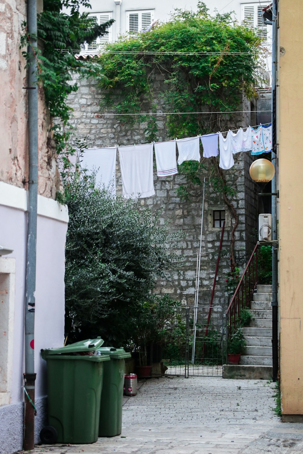 hung clothes near buildings and trash containers