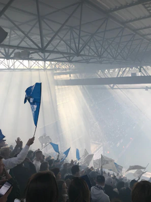 A panoramic view of the futuristic stadium filled with fans waving light blue and silver flags.