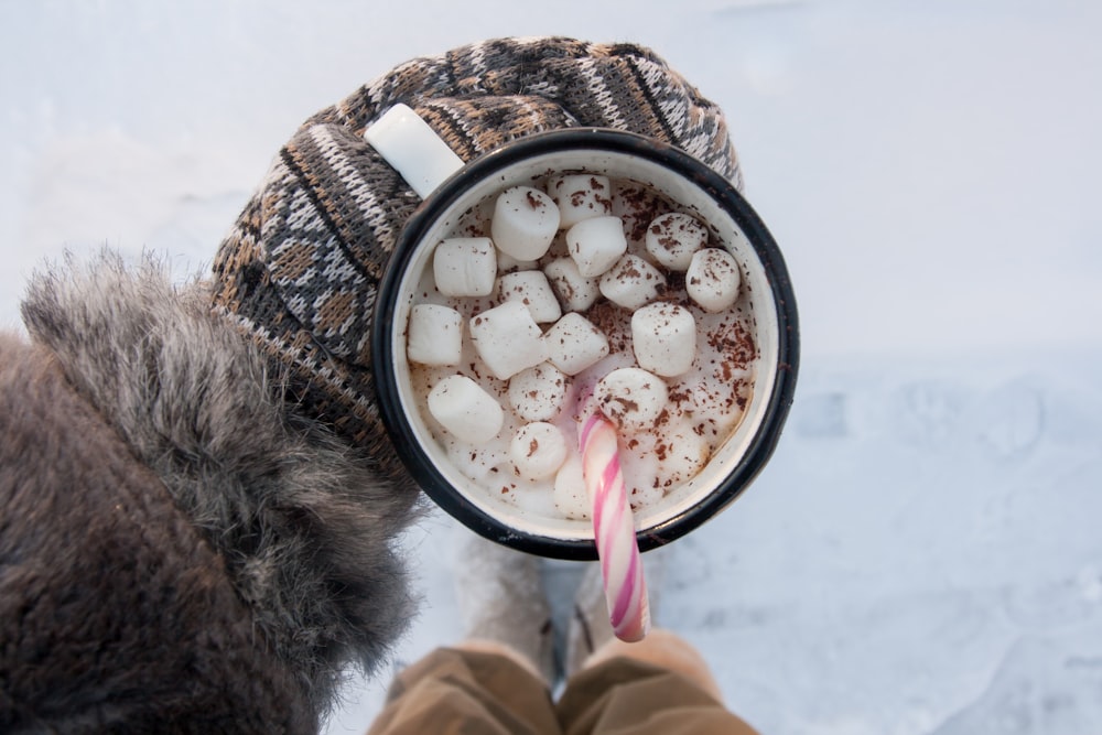 weißer und schwarzer Becher mit Marshmallow und Milch