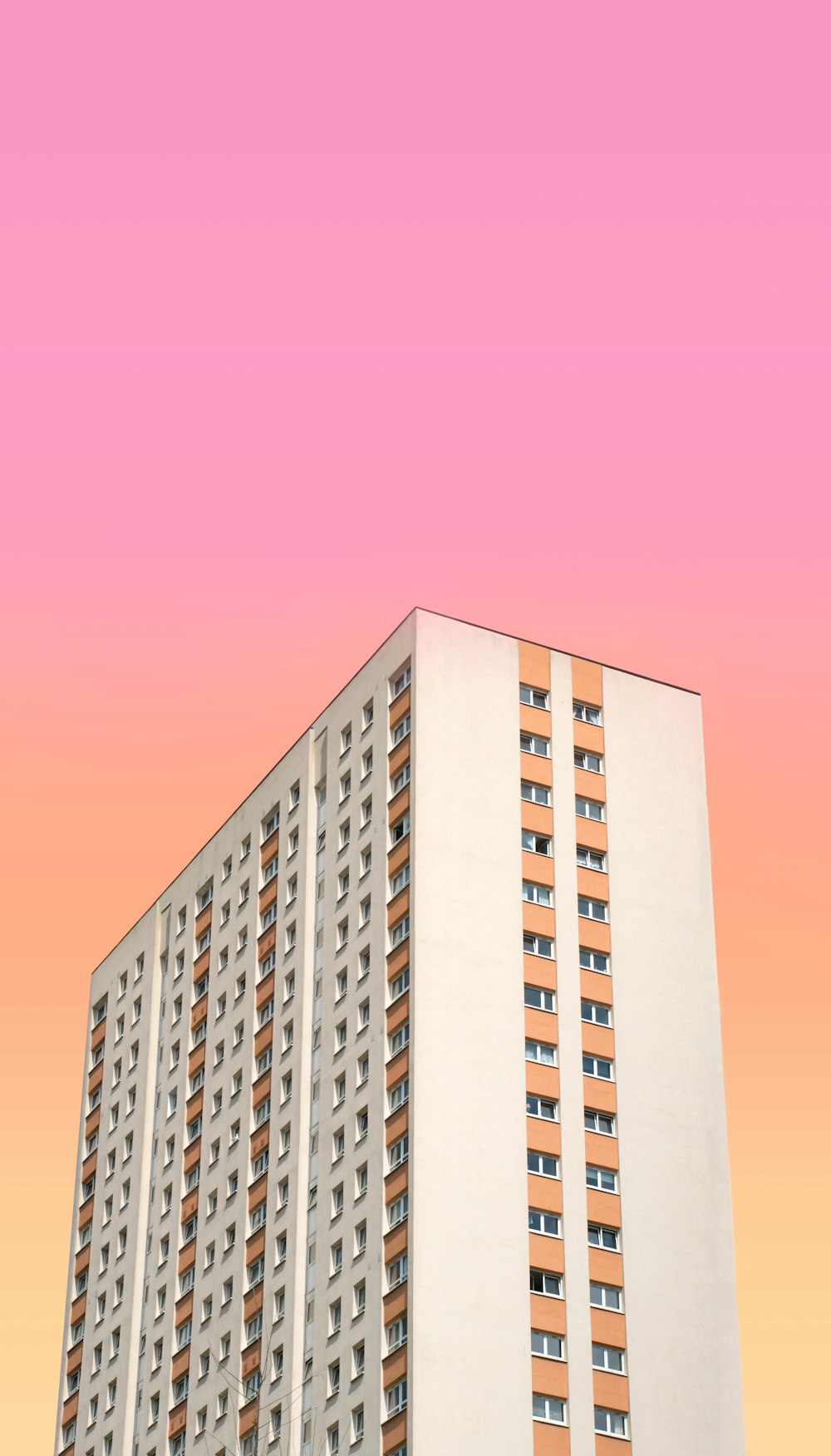 Photographie en contre-plongée d’un bâtiment en béton blanc et brun