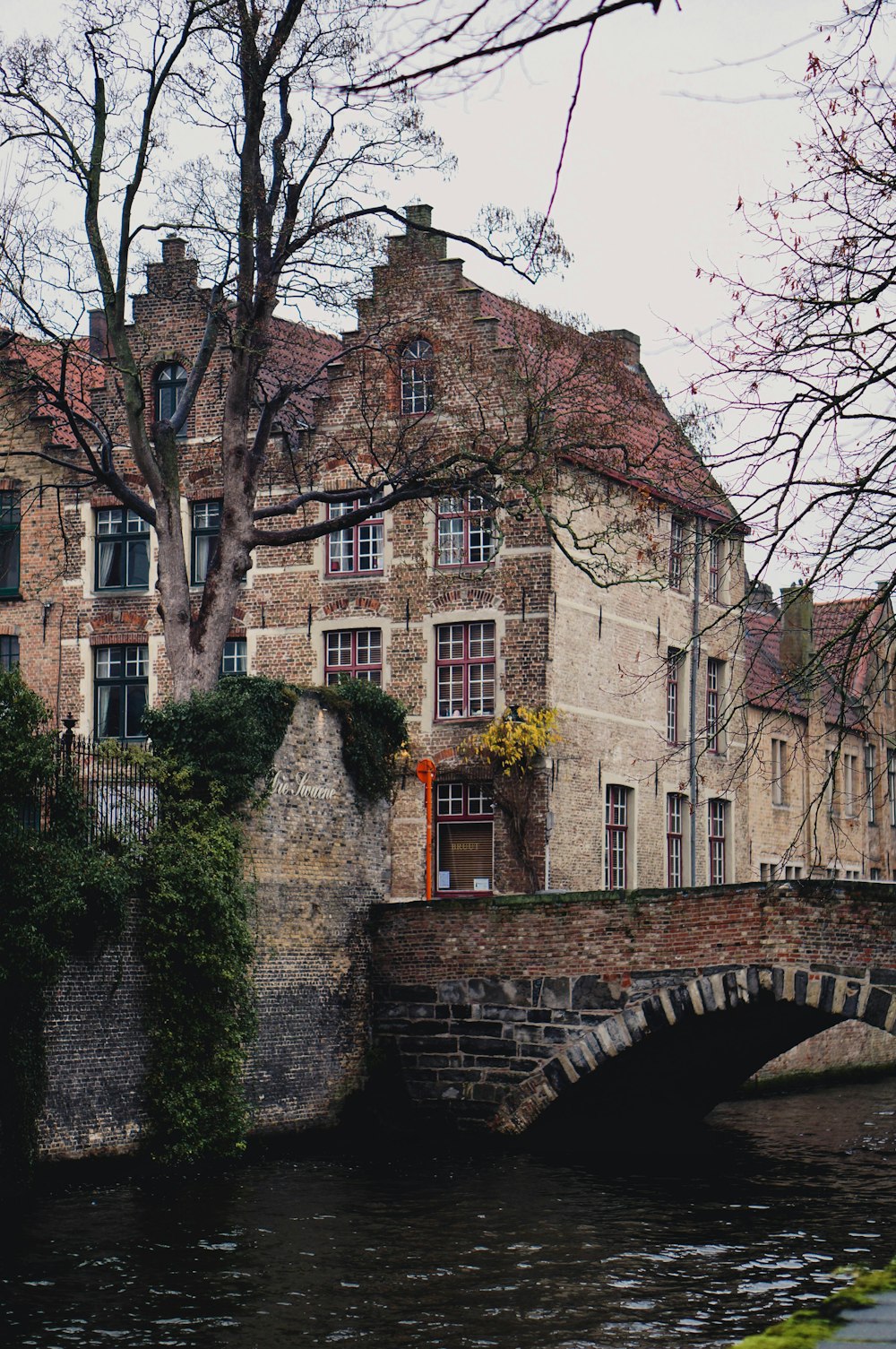 Voir la photographie d’un bâtiment et d’un pont en béton brun pendant la journée