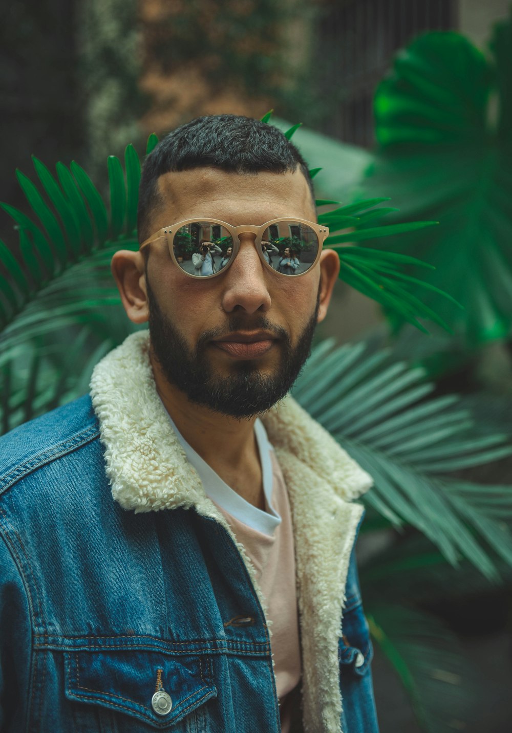 man wearing blue denim jacket and sunglasses taking selfie