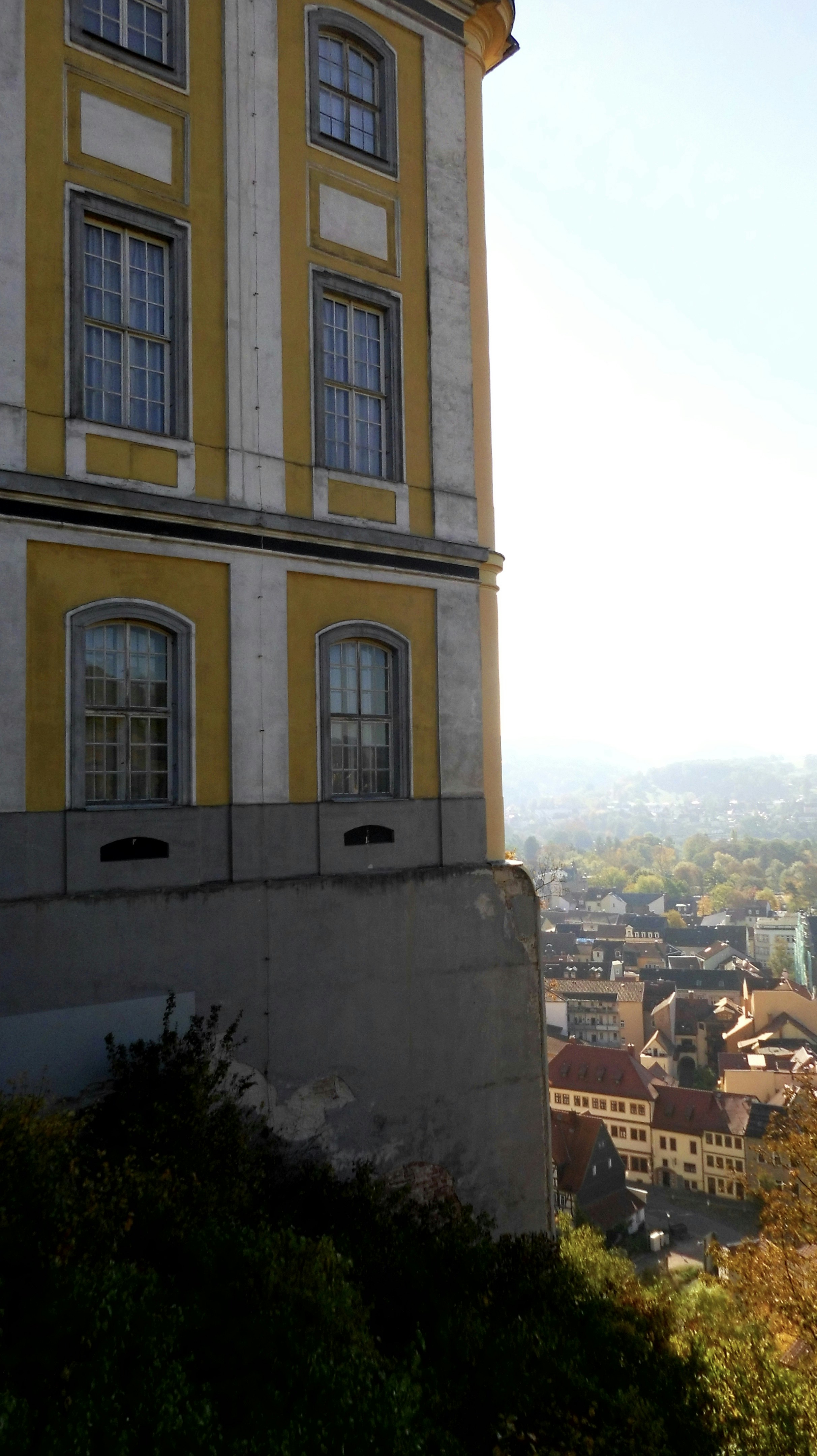 white and yellow concrete building overlooking houses at daytime