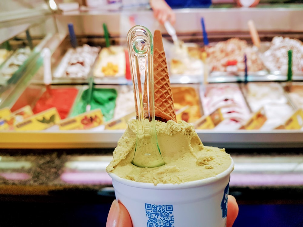 una persona che tiene in mano una tazza di gelato