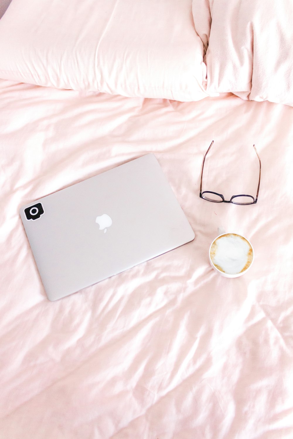 flat lay photography of a MacBook beside eyeglasses and cup of coffee latte