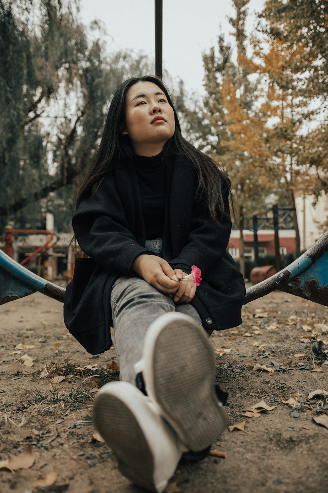 woman in black jacket and gray pants sitting outdoors