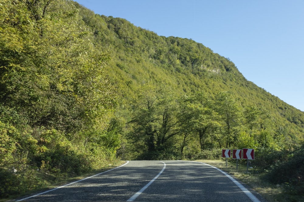 empty concrete pavement on road by mountain during daytime