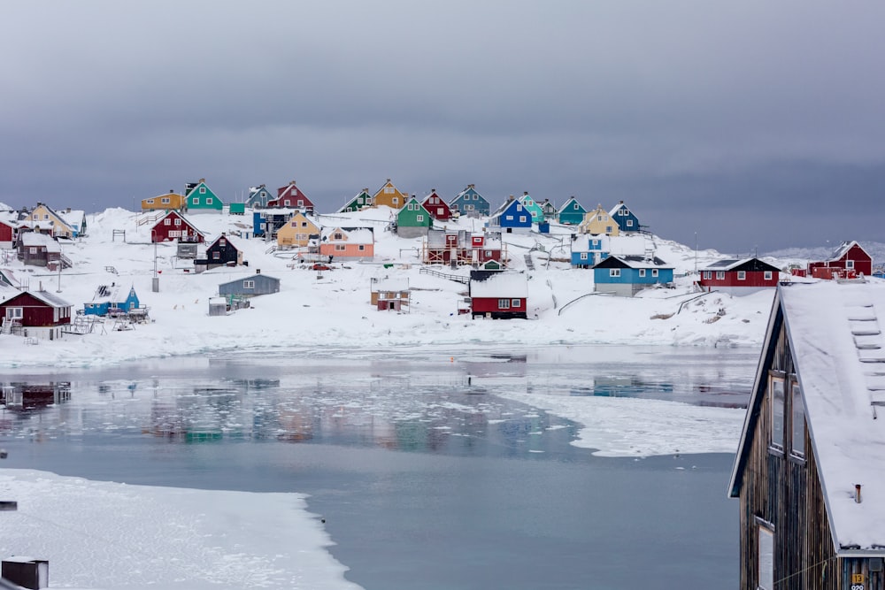 view photography of assorted-color houses near pond during daytime