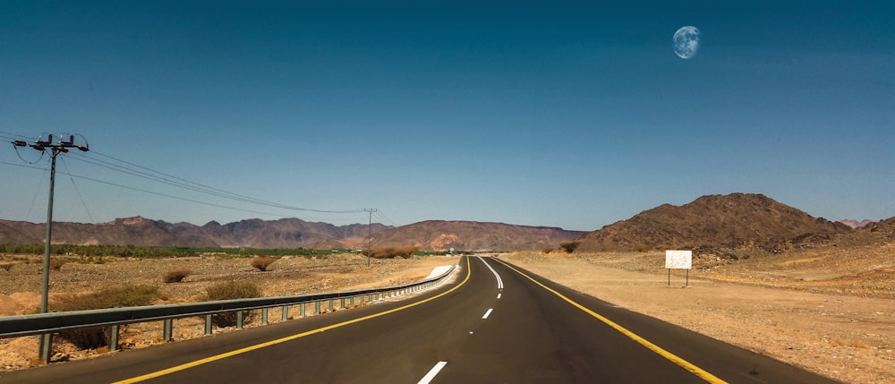 empty road by mountain during daytime