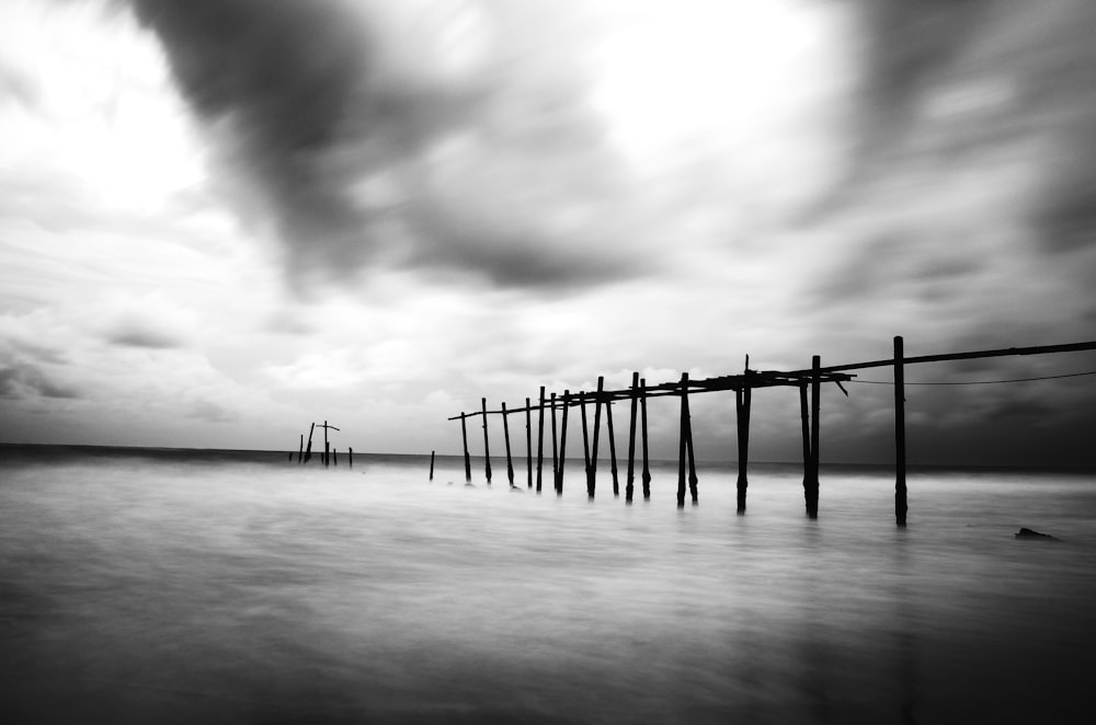 Une photo en noir et blanc d’une jetée par temps nuageux