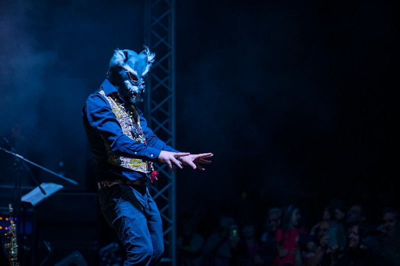 person in black jacket with mask standing in front of people