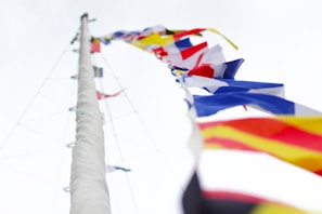 A vibrant close-up of nautical flags fluttering in the breeze by the seaside