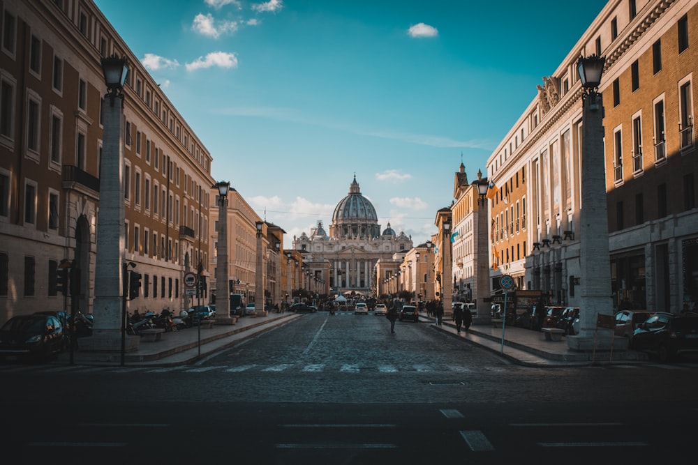 a city street with a domed building in the background