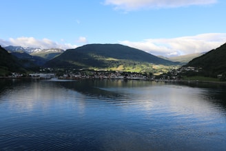 landscape photography of green mountain near body of water