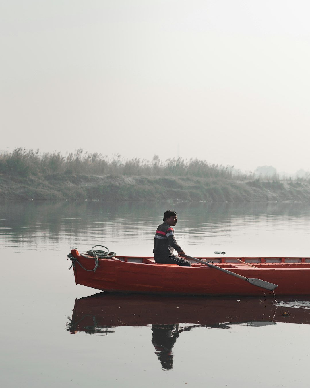 man sitting on orange canoe