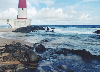 red and white lighthouse near sea during daytime