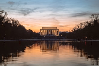 white concrete gazebo near body of water