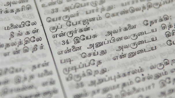 Close-up of a palm leaf manuscript with delicate Tamil script glowing softly under warm light.