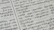 A close-up of a hand gently holding a palm leaf manuscript with intricate Tamil script.