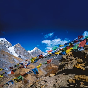 Snow-capped peaks of Leh with colorful prayer flags fluttering in the breeze.