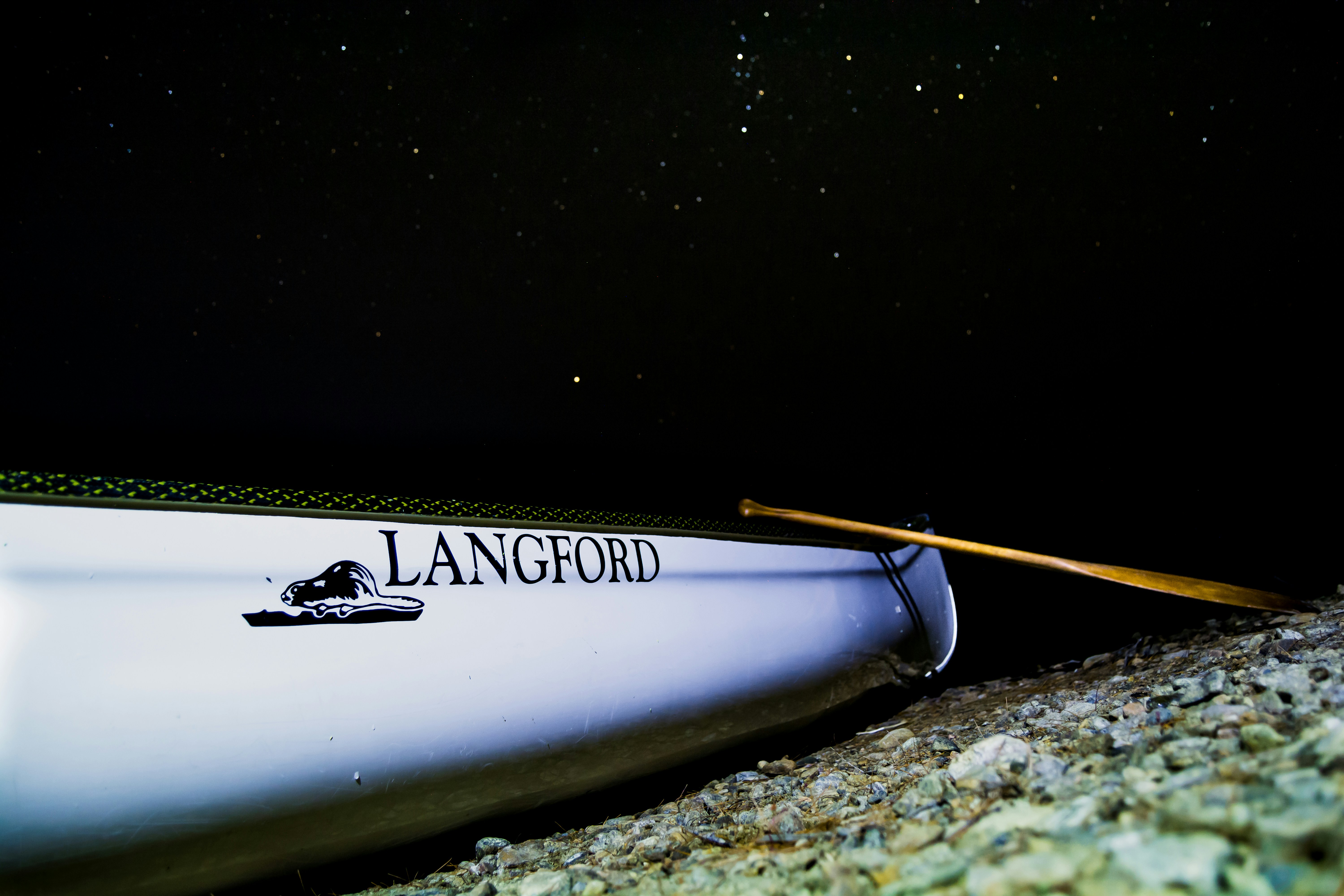 white Langford rowboat on shore